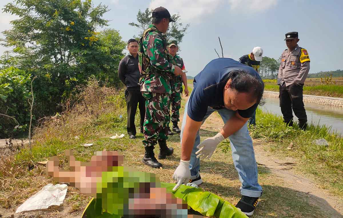 Petugas saat mengidentifikasi jenazah perempuan yang ditemukan tewas tergorok di Desa Keting, Kecamatan Jombang, Jember.