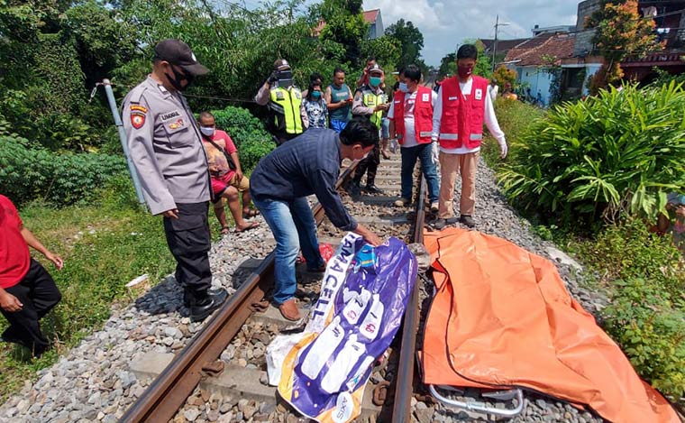 Petugas dibantu warga mengevakuasi jasad korban. 