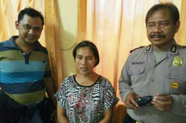 Sumiarti penjual kopi yang nyambi ngecer togel, akhirnya dijebloskan sel Mapolsek Porong.  Tampak tersangka diapit petugas. 