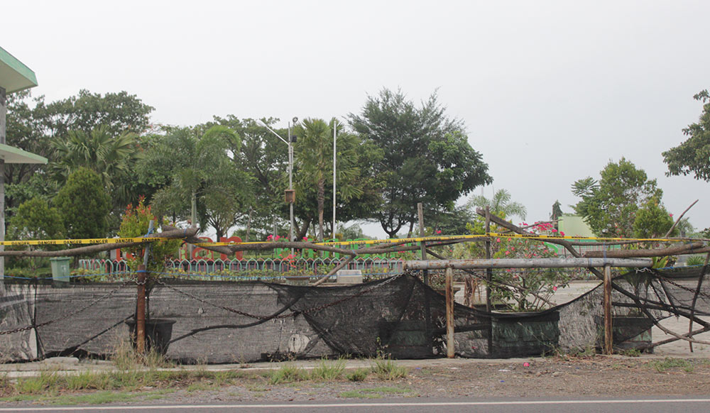 Kondisi pintu utama TPW yang masih tertutup dengan palang besi dan kayu. foto: MAULANA RIZQI/ BANGSAONLINE