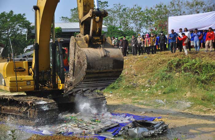 Pemusnahan miras di sekitar TPA Banjarsari menggunakan alat berat bego. 