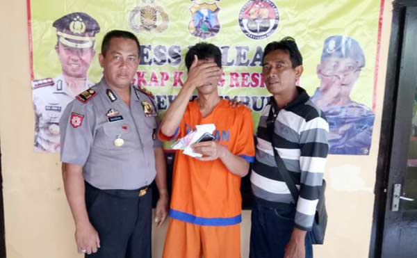Tersangka diapit petugas Polsek Krembung Sidoarjo.