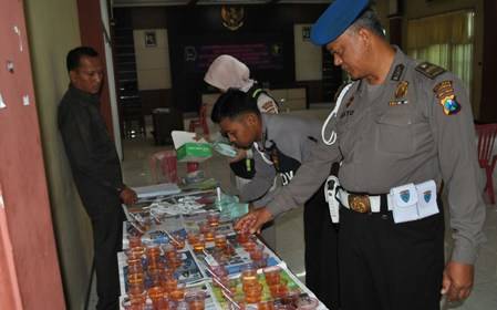 TES URINE – Anggota Propam tengah melihat urine milik anggota Polres Lamongan, Senin (15/9/2014). Foto : haris sugianto/BangsaOnline

