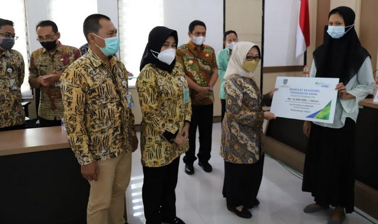 Bupati Jombang, Hj. Mundjidah Wahab menyerahkan beasiswa pendidikan pada ahli waris peserta JKM.