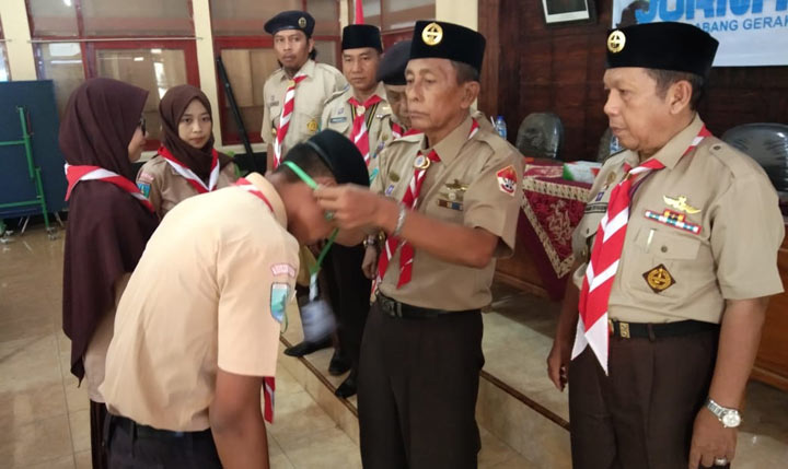 Ketua Harian Kwarcab Sumenep, Drs. H. M. Siraj Aidy, M.Si. saat memakaikan ID card kepada peserta pelatihan.