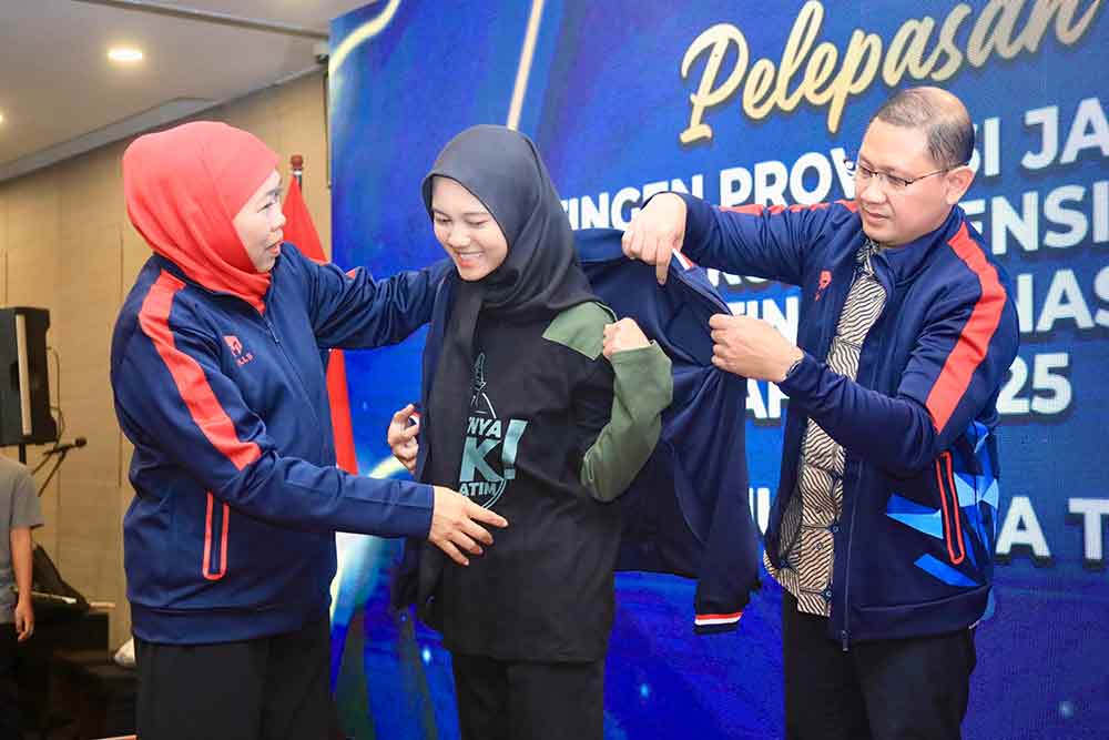 Gubernur Jatim, Khofifah Indar Parawansa (kiri) memasangkan jaket untuk kontingen Jatim bersama Kepala Dinas Pendidikan Jatim, Aries Agung Paewai (kanan). (Ist)