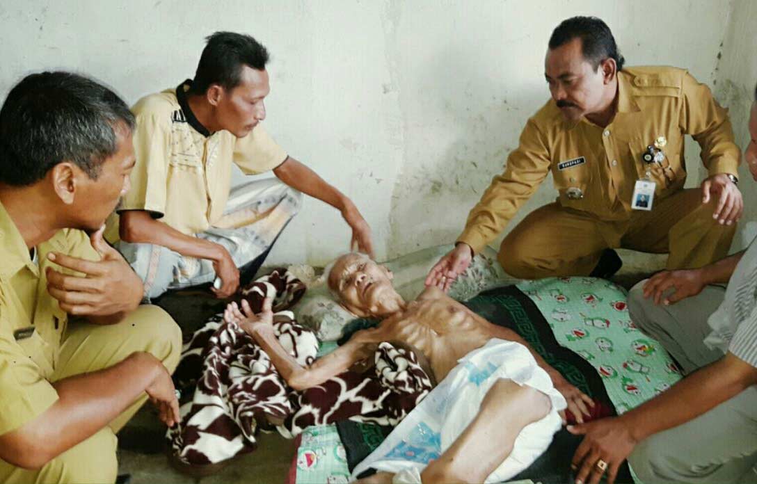Nenek sebatang kara, Supiyani ketika dijenguk perangkat kecamatan beberapa waktu lalu. foto: SYUHUD/ BANGSAONLINE