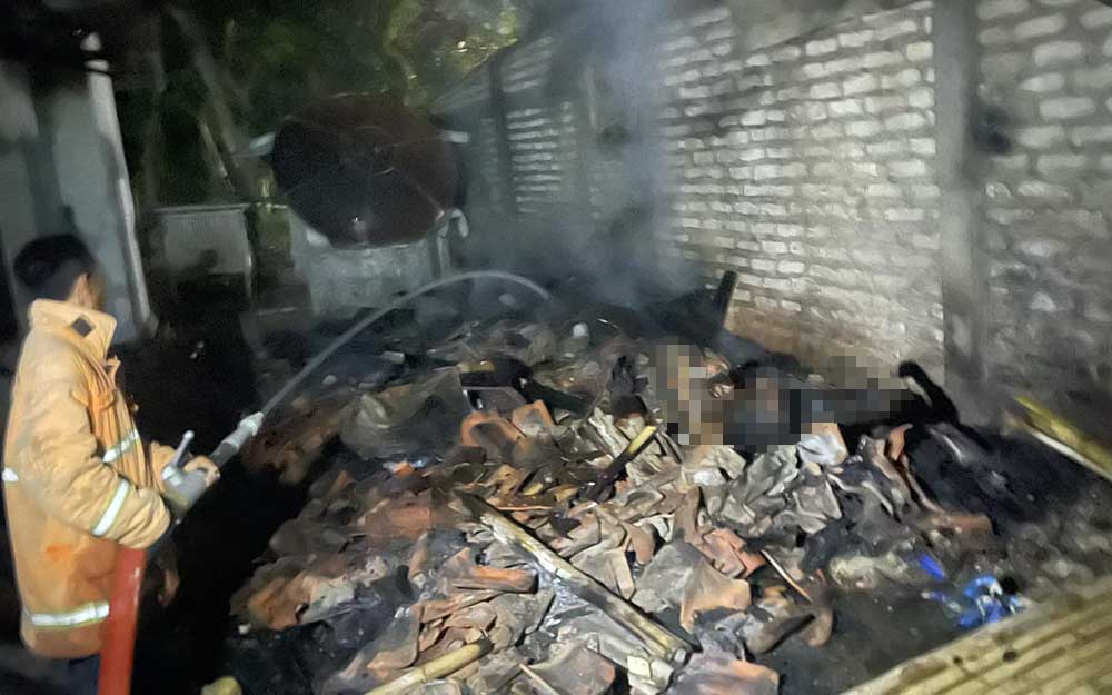 Petugas damkar saat melakukan pembasahan di titik lokasi kebakaran.