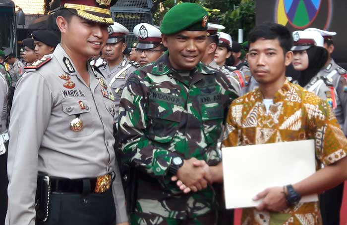 Kapolres AKBP Wahyu Sri Bintoro dan Dandim 0817 Letkol (Kav) Widodo Pujianto saat menyerahkan penghargaan. foto: SYUHUD/ BANGSAONLINE