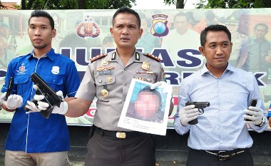 Kapolres Gresik AKBP Ady Wibowo SIK menunjukkan foto anggota BIN Gadungan, Eko Projo S yang tewas ditembak petugas beserta barang bukti. (shopii/BANGSAONLINE)