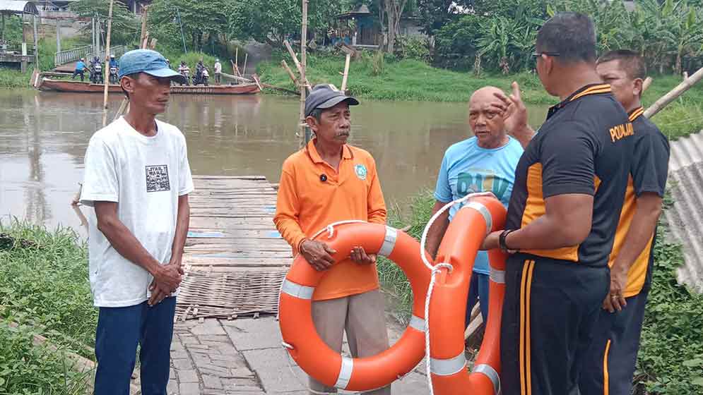 Kapolsek Balongbendo, AKP Sugeng Sulistiyono (kanan), saat berbincang dengan penyebrang perahu, memastikan semua dalam keadaan baik. (Ist)