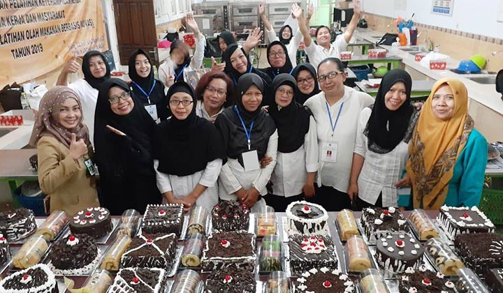 Kasi Pelatihan Kerja Disnaker Kota Malang Tjuratna dan Instruktur pelatihan keterampilan Nissa Hansawati bersama para peserta pose bareng dengan hasil karya kuenya.