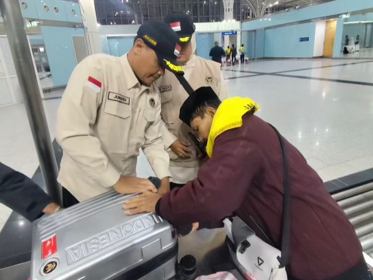Jumardi saat mengecek bagasi jemaah di jalur fast track bandara Madinah. Foto: MCH 2026.