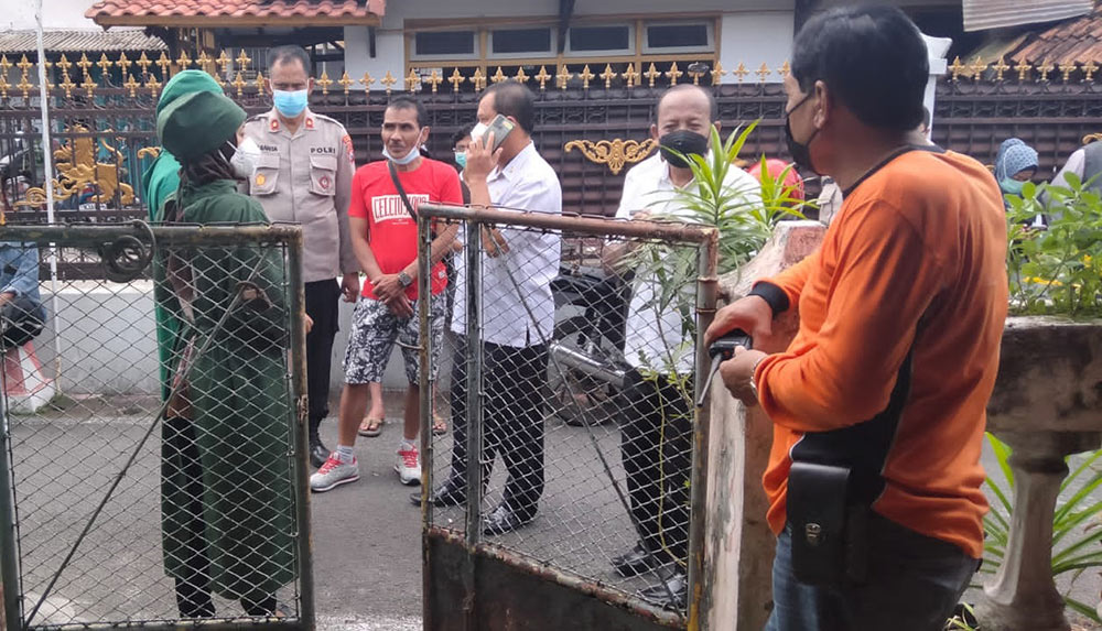 Sejumlah petugas saat berada di depan rumah korban tewas gantung diri di Kota Blitar. foto: AKINA/ BANGSAONLINE