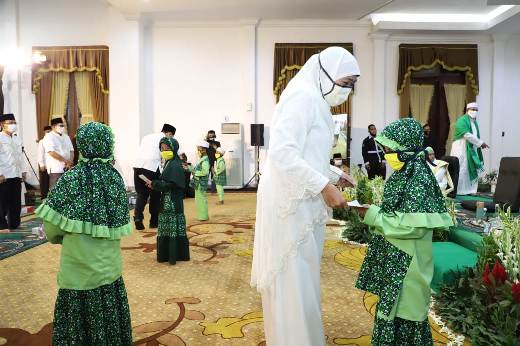 Gubernur Jawa Timur Khofifah Indar Parawansa membagikan amplop berisi uang kepada para peserta Khotmil Quran saat peringatan Nuzulul Quran di Gedung Negara Grahadi Surabaya, Sabtu (9/5/2020). foto: ist/ bangsaonline.com  