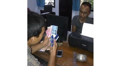 Tersangka beserta barang bukti berupa uang saat diperiksa petugas. (Gunadhi/BangsaOnline)