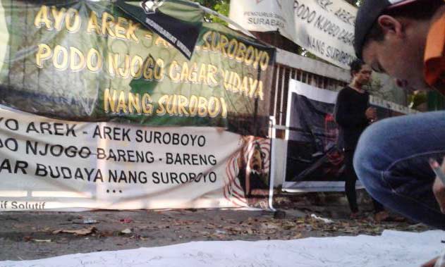 Para mahasiswa dan pemuda Surabaya menandatangani komitmen untuk menjaga bangunan cagar budaya yang ada di Surabaya di depan Rumah Radio Bung Tomo yang telah dibongkar di Jalan Mawar, Jumat (13/5). foto: suarasurabaya