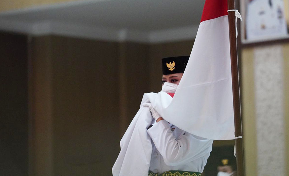Salah satu Anggota Paskibraka Kota Batu mencium bendera merah putih saat dikukuhkan.