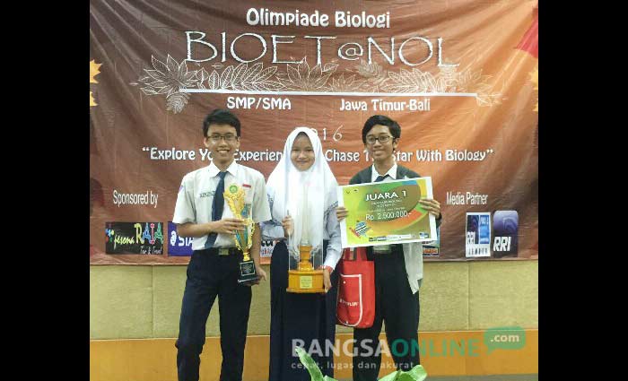 Siswa SMPN 1 Gresik menunjukkan piala juara Olimpiade Sains. foto: SYUHUD/ BANGSAONLINE