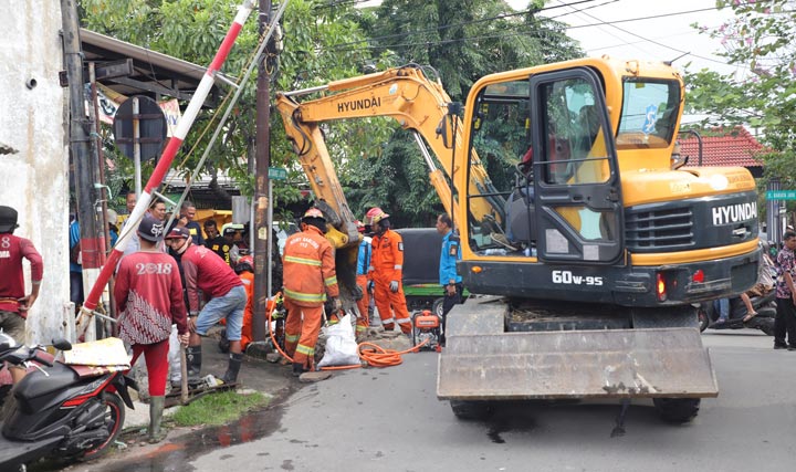 Alat berat sedang membongkar bangunan permanen yang berdiri di atas saluran selokan. foto: ist.