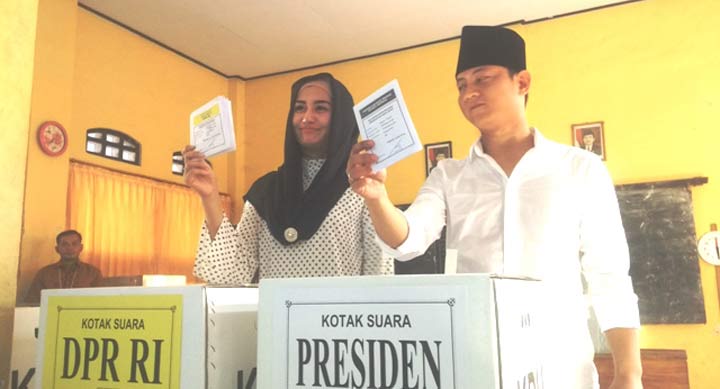 Wabup Trenggalek Moh. Nur Arifin didampingi sang Istri Novita Hardiny saat hendak memasukkan surat suara di TPS 11 Kelurahan Ngantru. foto: HERMAN S/ BANGSAONLINE
