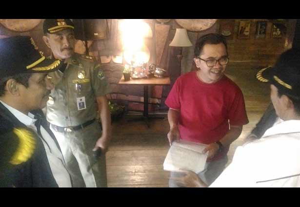 Seorang pekerja Cafe Coloni saat diperingatkan oleh petugas gabungan agar tidak melakukan aktivitas membuka cafe selama bulan suci Ramadhan, Kamis (31/05). foto: IWAN/ BANGSAONLINE