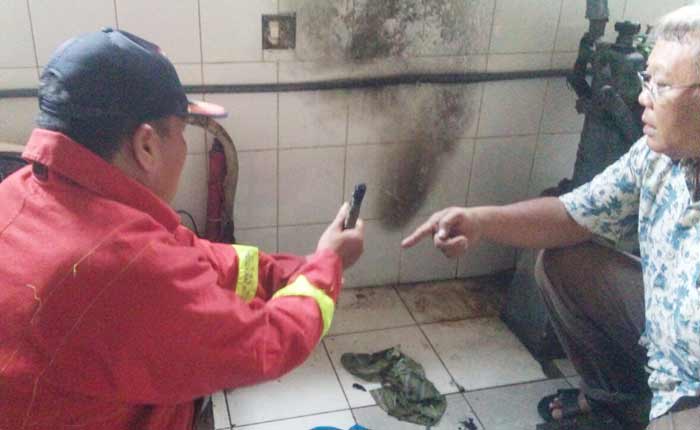 Petugas menunjukkan selang regulator yang menjadi pemicu kebakaran.