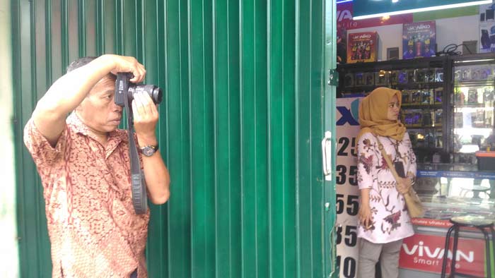 Iptu Subandi dari Unit Olah TKP (Inafis) saat melakukan identifikasi dan olah TKP di konter Abunawas Cell, Jumat (06/04). Foto: IWAN I/BANGSAONLINE.