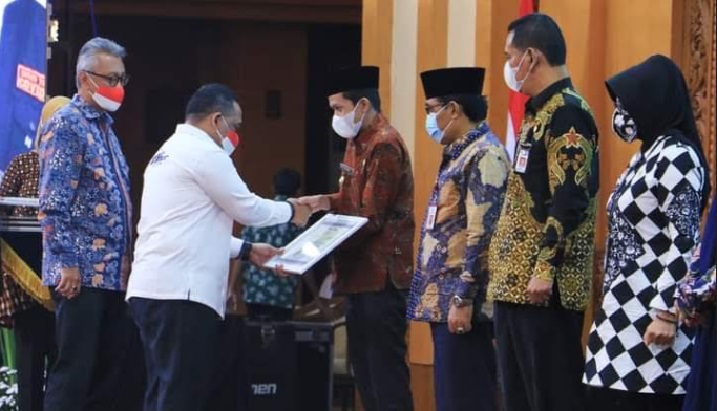 Wabup Trenggalek Syah Natanegara (nomor 4) dari kanan saat terima penghargaan dari BP2MI. foto: HERMAN/ BANGSAONLINE