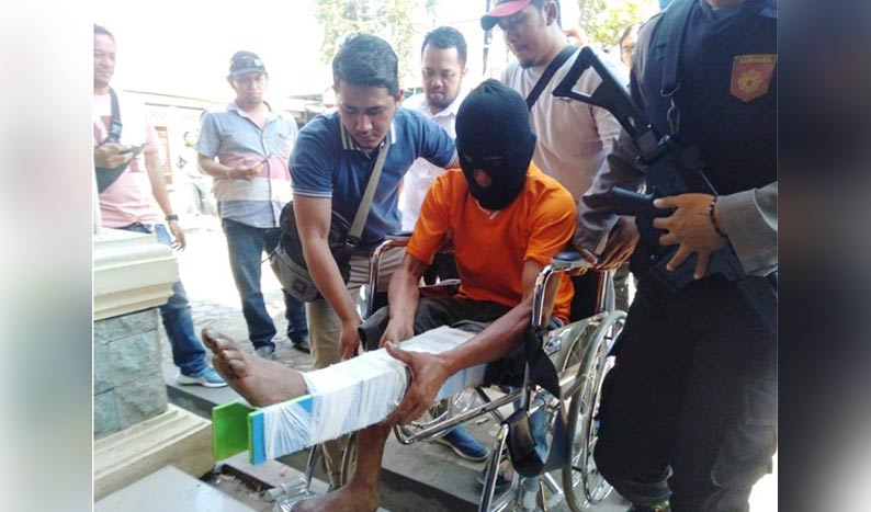 Pelaku dalam kondisi kaki di-spalk hendak dihadirkan dalam rilis usai ditangkap. foto: SOFFAN/ BANGSAONLINE