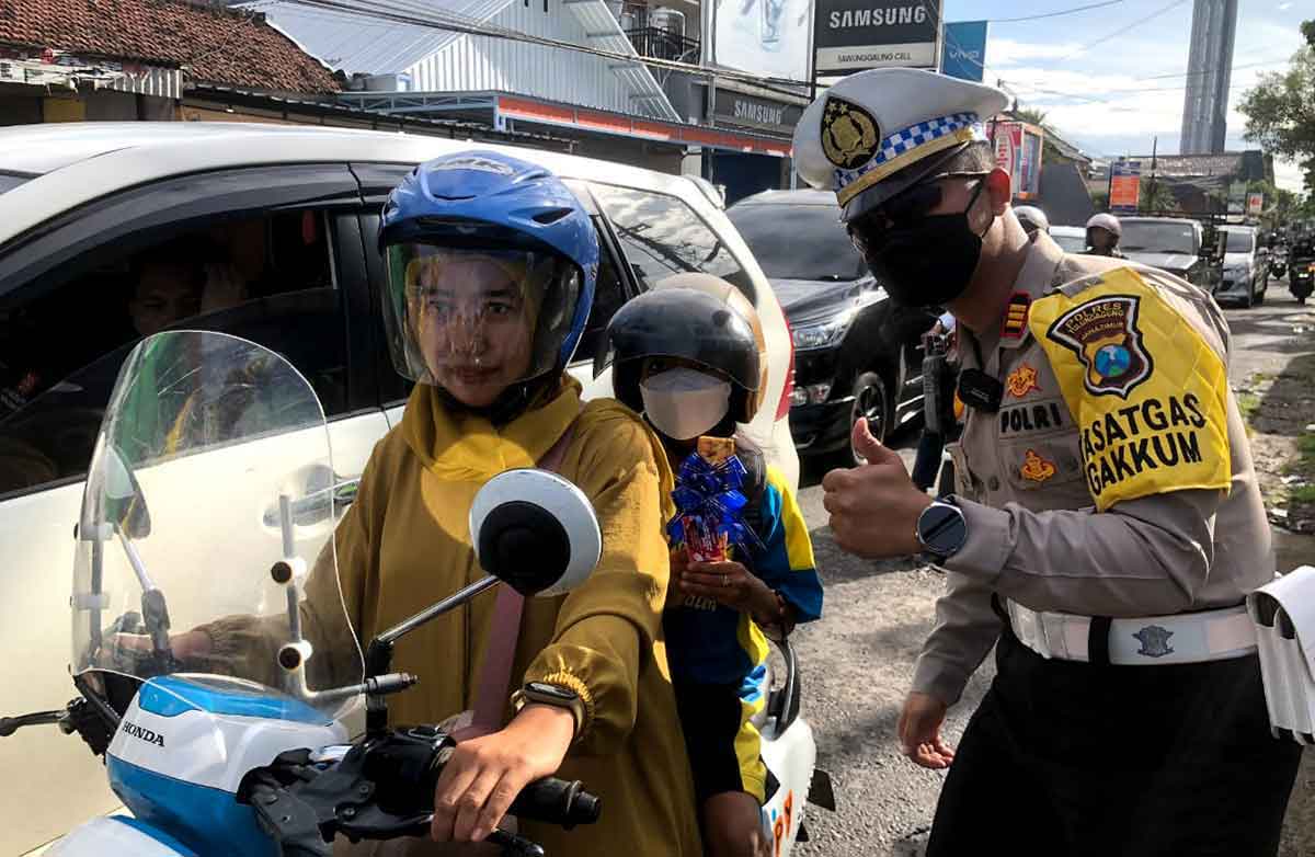 Petugas dari Satlantas Polres Tulungagung saat membagikan cokelat untuk pengendara.