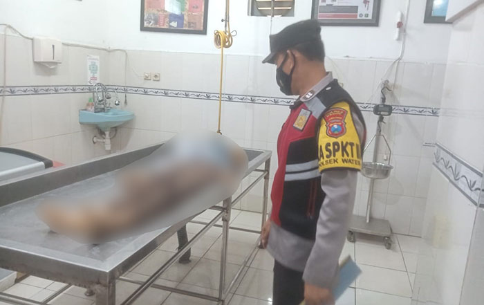 Petugas ketika melihat korban kecelakaan yang tewas terlindas truk di Jalan Raya Tawang, Kecamatan Wates, Kabupaten Kediri.