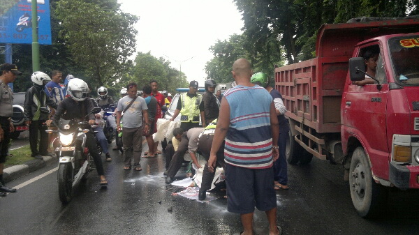 Korban yang tewas terlindas truk gandeng ditutupi koran di
tengah jalan, kemarin. foto : nanang ichwan/BangsaOnline
