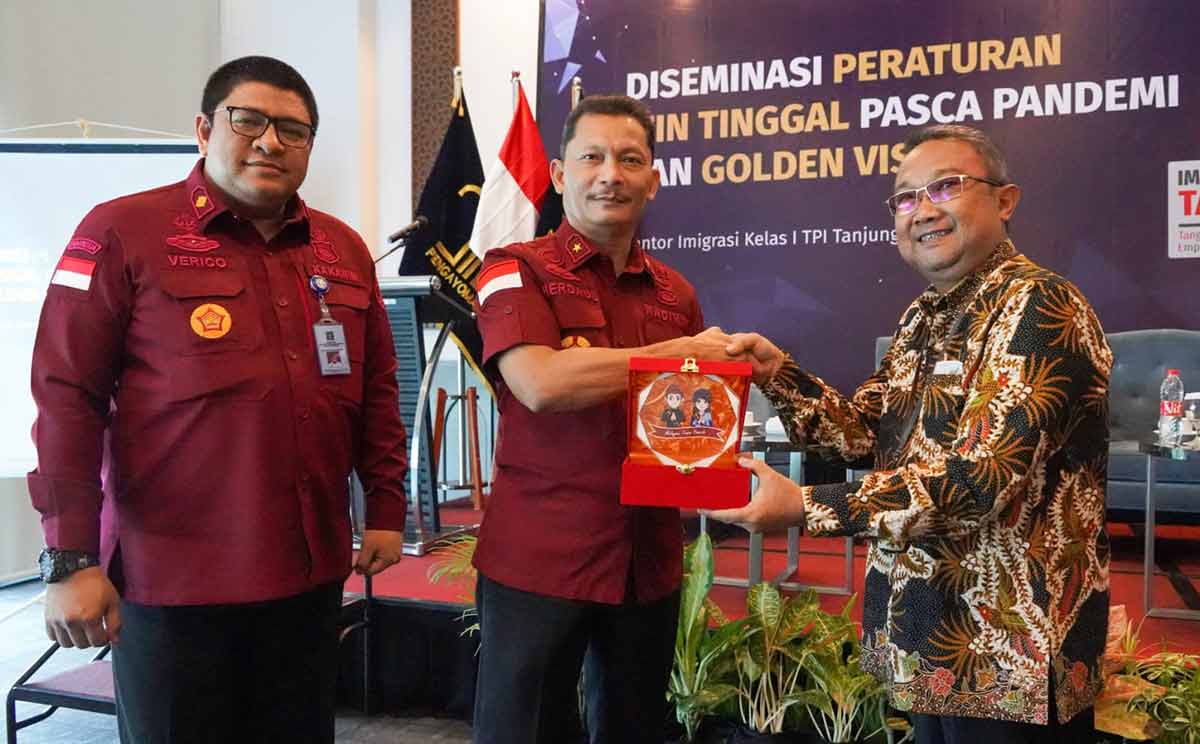Kadiv Keimigrasian Kanwil Kemenkumham Jatim, Herdaus (tengah), saat memberikan cendera mata kepada Koordinator Alih Status Keimigrasian, Tessar Bayu Setyaji, dan disaksikan Kakanim Tanjung Perak, Verico Sandi.
