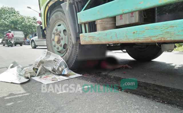 Korban yang terlindas truk gandeng di Japan Cemara Kota Blitar sebelum dievakusi petugas. foto: AKINA/ BANGSAONLINE