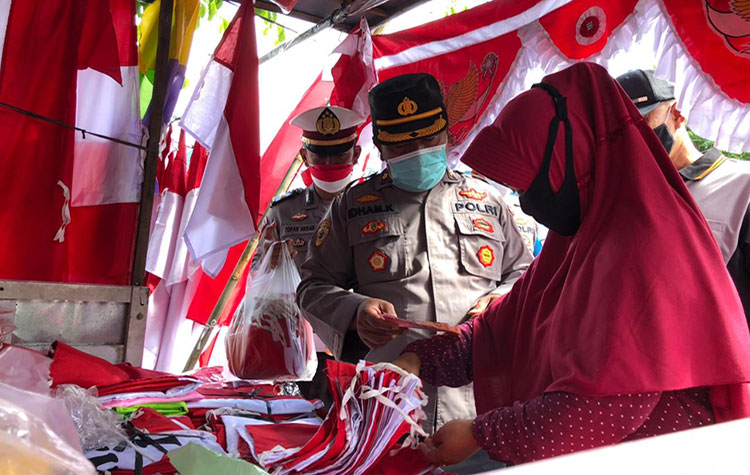 Polresta Banyuwangi borong bendera merah putih milik pedagang musiman. (foto: ist)