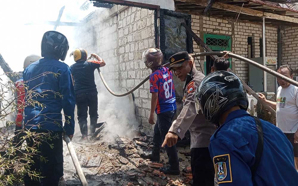 Tim damkar melakukan pembasahan usai berhasil memadamkan api.
