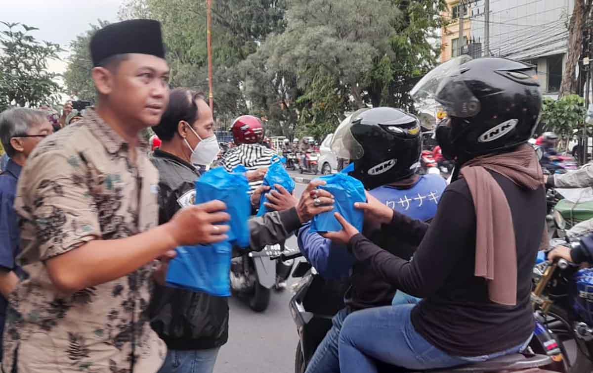 Anggota PWI Sidoarjo saat membagikan takjil ke pengguna jalan. Foto: Ist