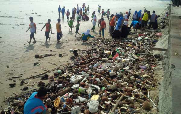PEDULI: Para anak yatim dan pendampingnya melakukan bakti sosial bersih pantai utara yang berada di kawasan Jalan RE Martadinata Tuban. foto: suwandi/BANGSAONLINE