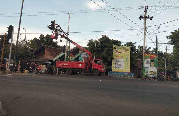Pemasangan tiang TL di perempatan Gading Rejo. foto: SUPARDI/ BANGSAONLINE