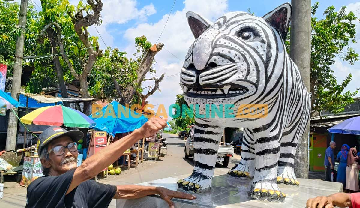 Mbah Suwari dan patung macan putih hasil karyanya. Foto: MUJI HARJITA/BANGSAONLINE