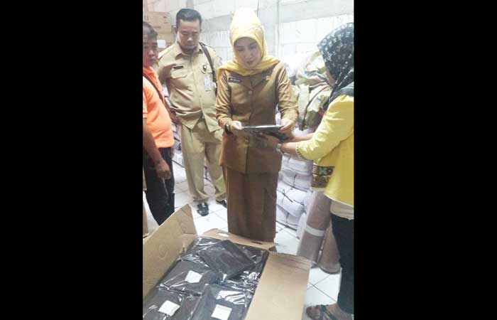 Nur Maslicah, Kabid Dikmen Dispendik Gresik, saat mengecek kain seragam gratis. foto: SYUHUD/ BANGSAONLINE