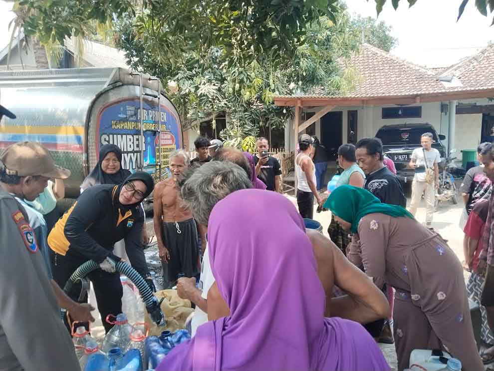 Kapolsek Sukorejo AKP Marti saat membagikan air bersih kepada warga Kenduruhan.