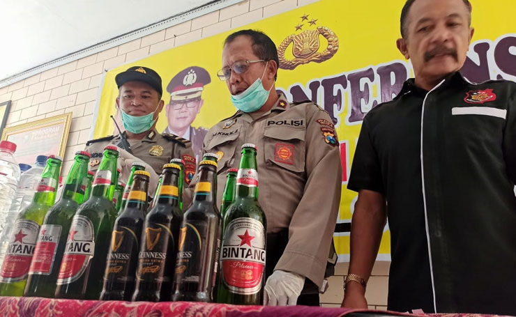 Petugas memamerkan barang bukti sejumlah botol miras yang berhasil diamankan saat operasi pekat.