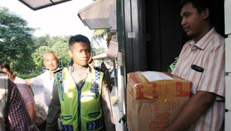 AMANKAN DOKUMEN – Tim Tipikor Bareskrim Polri terlihat membawa satu kardus berkas usai menggeledah kantor distributor UPS, di Ruko Graha Indah B-2 Jalan Gayung Kebonsari, Surabaya, Rabu (22/4). foto: rusmiyanto/BANGSAONLINE