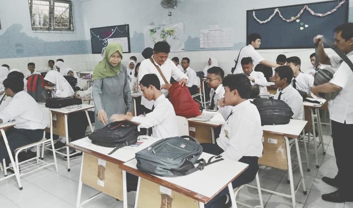 Petugas OPD gabungan Kota Surabaya saat memeriksa HP milik para siswa.