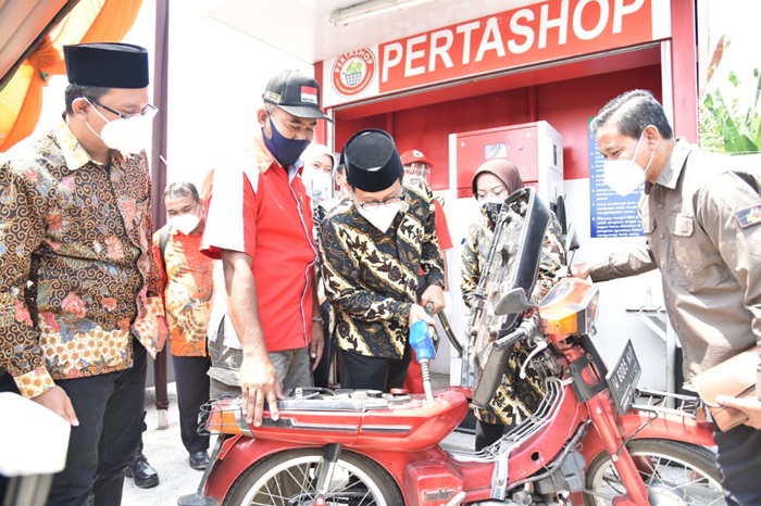 LAYANI WARGA: Abdul Halim Iskandar mengisi BBM ke salah satu motor warga saat mengunjungi usaha milik BUM Desa di Desa Jemirahan Jabon, Jumat (3/9/2021). foto: istimewa