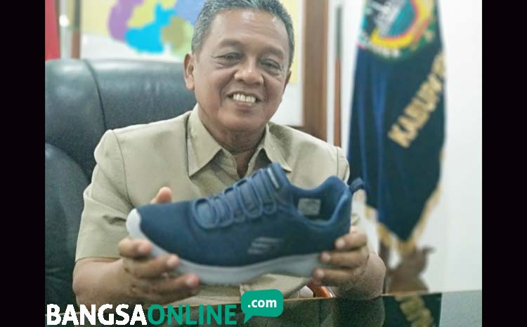 Bupati Indartato saat menunjukkan salah satu koleksi sepatu Skechers jenis Go Run pada wartawan. foto: YUNIARDI S/ BANGSAONLINE