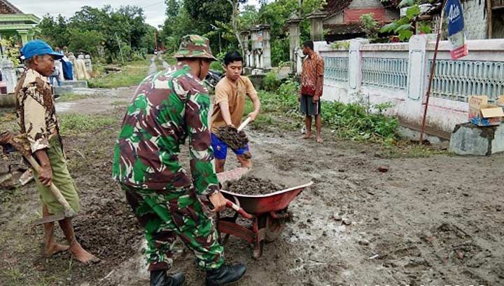 Babinsa Koramil Balerejo Sertu Dadi bersama masyarakat kerja bakti pengurukan jalan.