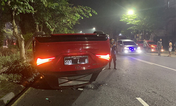 Sebuah mobil Mercedes Benz bernopol B 7 DUS oleng dan terbalik di depan GKI Diponegoro, Surabaya, Jumat (01/04) sekira pukul 00.21 WIB. Foto: Pikiran rakyat